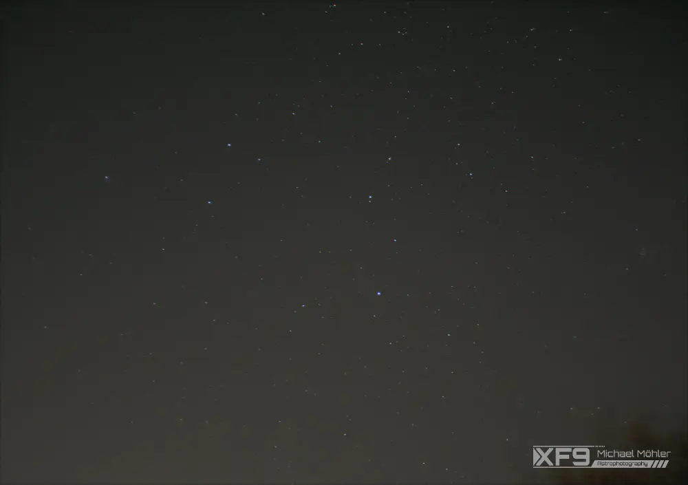 A star field with its brightest stars resembling roughly a lion